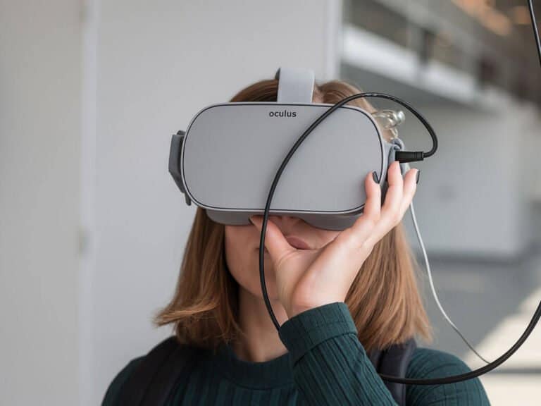 نص بديل للصورة: شخص يستخدم نظارة Oculus للواقع الافتراضي في بيئة داخلية حديثة.